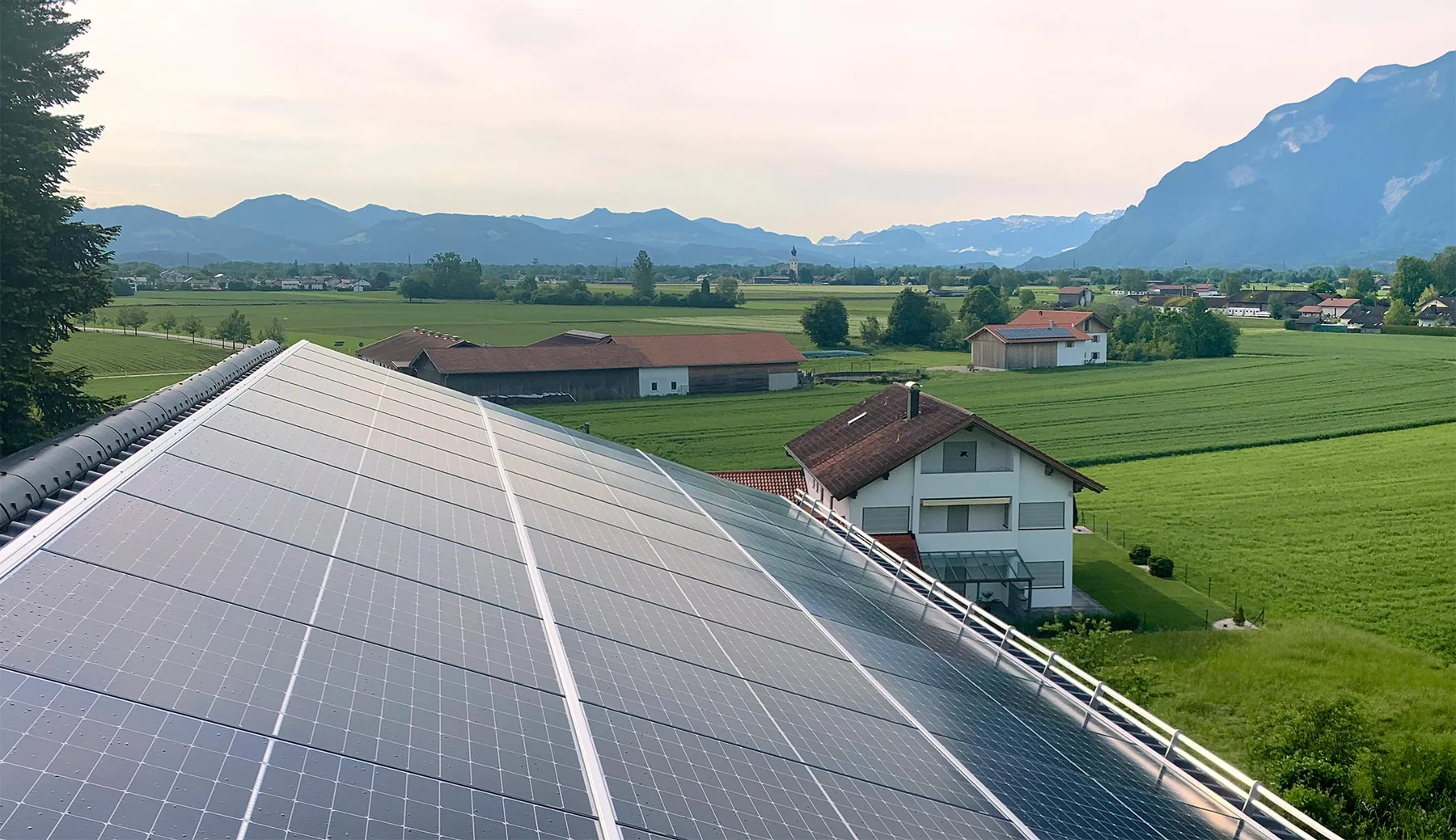 Photovoltaikmodule auf einem Dach vor der Berglandschaft bei Ainring